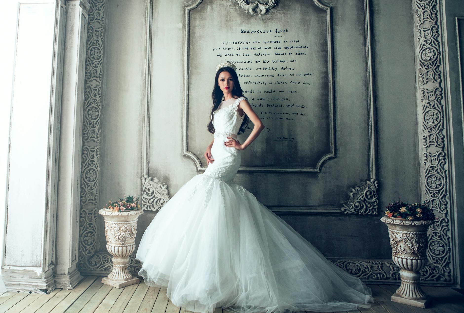 woman wearing white wedding gown standing beside gray painted wall